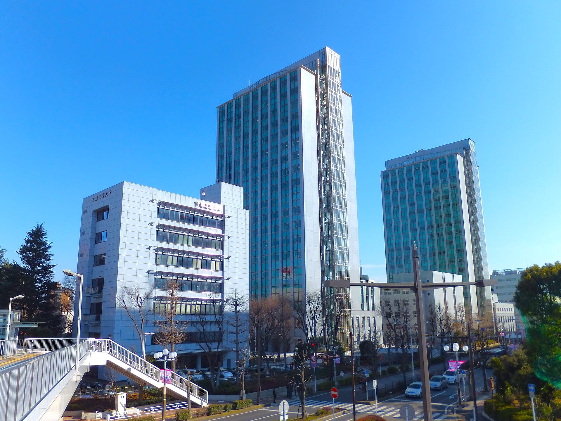 Glass-fronted towers on the Tsudanuma Campus of the Chiba Institute of Technology under a blue sky