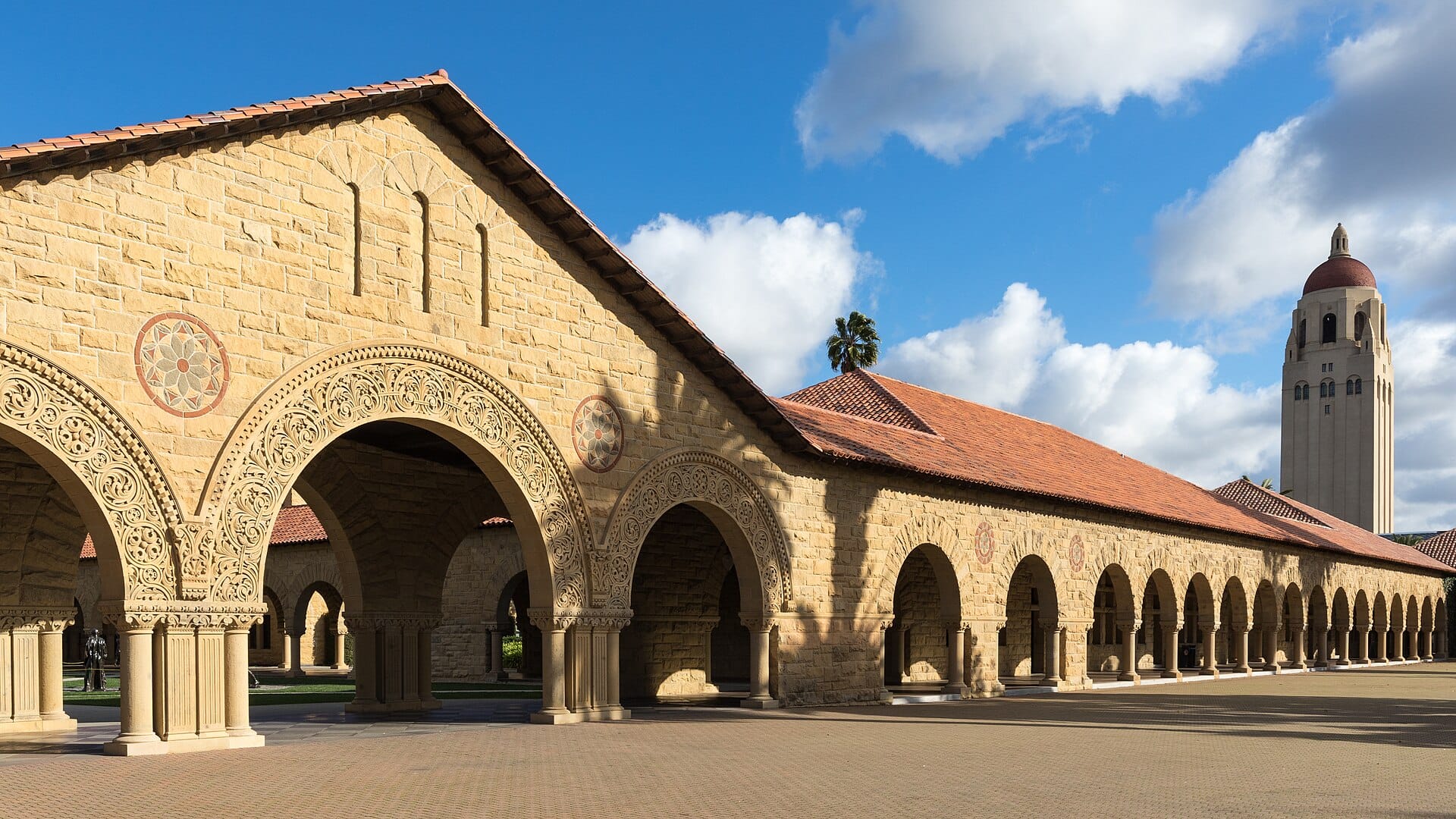 Sandstone arcades at Stanford University with Hoover Tower rising in the distance
