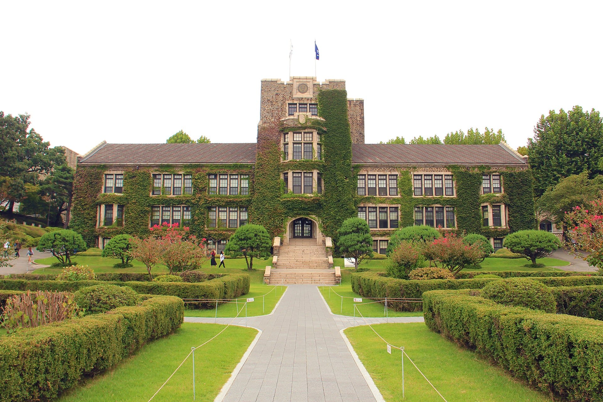 Ivy-covered Underwood Hall at Yonsei University approached by a path between clipped hedges